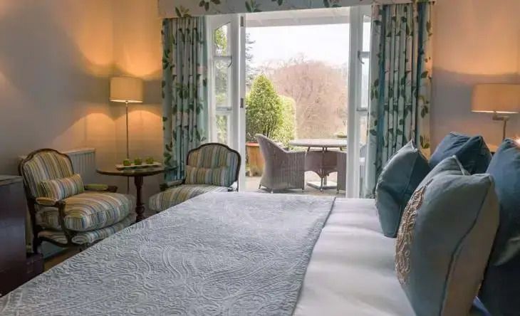 Helles Zimmer mit Doppelbett und Blick auf Terrasse im Chewton Glen Hotel