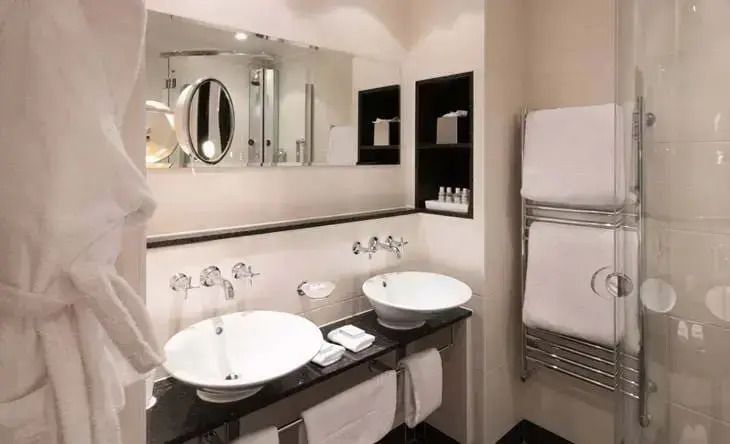 Luxuriöses Badezimmer mit Doppelwaschbecken und großzügigem Spiegel im Chewton Glen Hotel