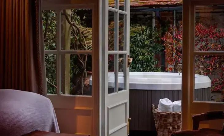 Private Terrasse mit Whirlpool umgeben von üppigem Grün