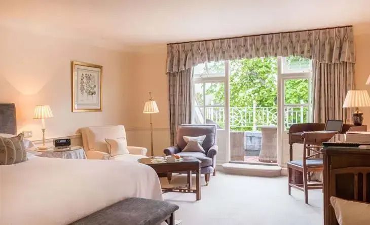 Klassisches Doppelzimmer mit eleganten Möbeln und Balkonzugang.