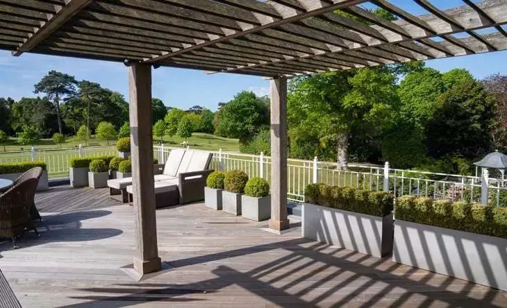 Geräumige Terrasse mit Sitzmöbeln und Blick auf eine grüne Landschaft.