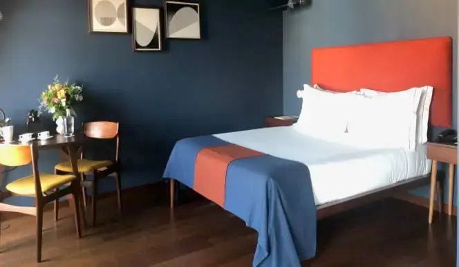 Vintage Superior Doppelzimmer mit blauem Bettüberwurf und moderner Kunst an der Wand