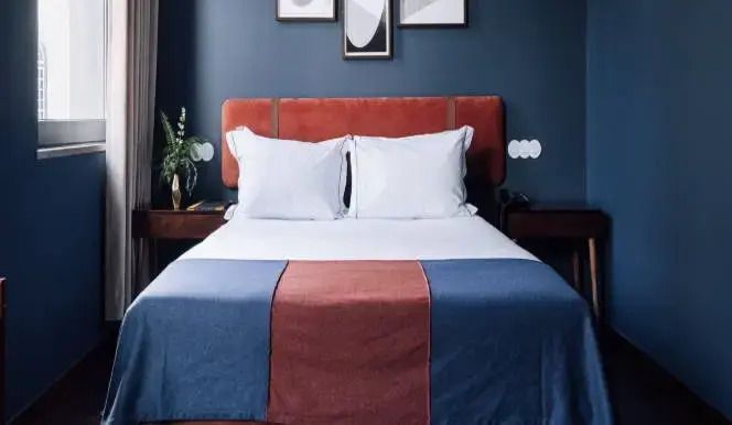 Hotelzimmer im Vintage-Stil mit Doppelbett und künstlerischen Wandbildern