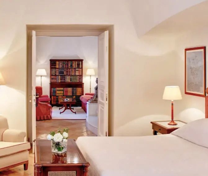 Elegantes Schlafzimmer mit Doppelbett und Blick in einen gemütlichen Loungebereich