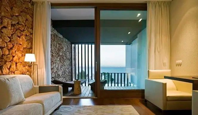Zimmer mit Zugang zum Balkon und Blick auf das Meer im Hintergrund