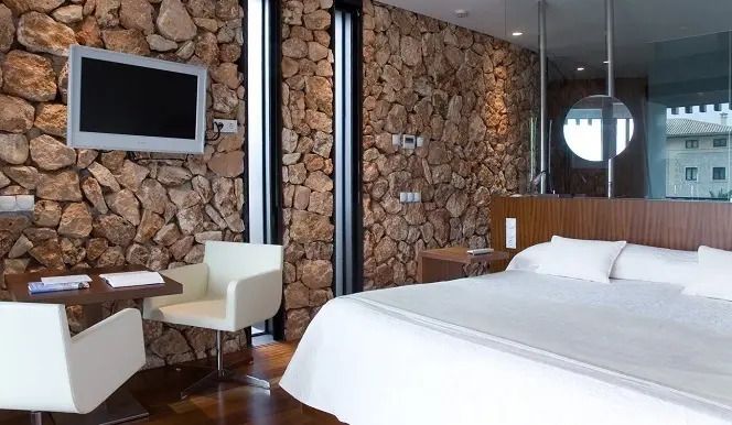 Zimmer mit Natursteinwand und moderner Einrichtung
