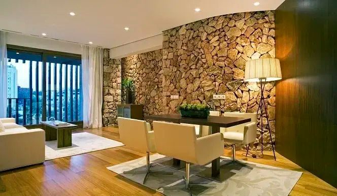 Essbereich in einer Suite mit Natursteinwänden und Designerstühlen