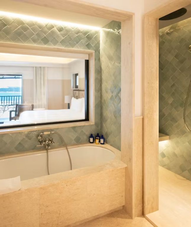 Badezimmer mit stilvollem Design und Blick auf das Meer durch ein großes Fenster