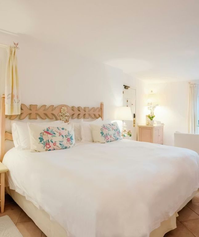 Helles Schlafzimmer mit Doppelbett und dekorativen Kissen im Hotel Pitrizza.