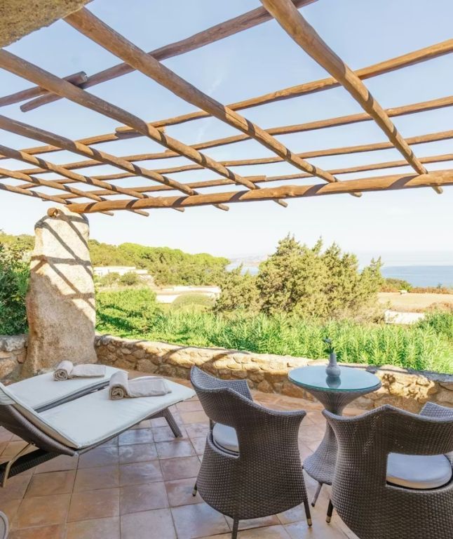 Sonnige Terrasse mit Liegen und Blick aufs Meer