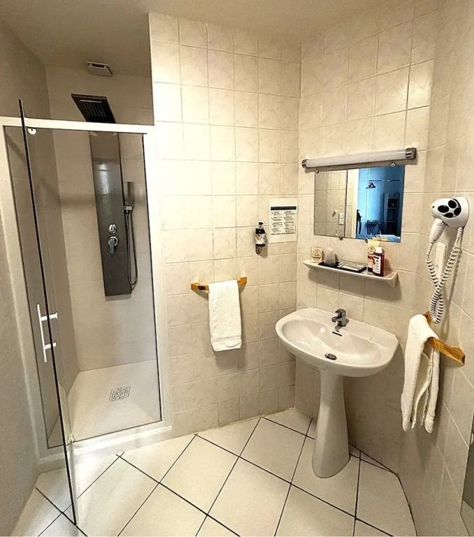 Helles Badezimmer mit moderner Dusche, Waschbecken und Fön