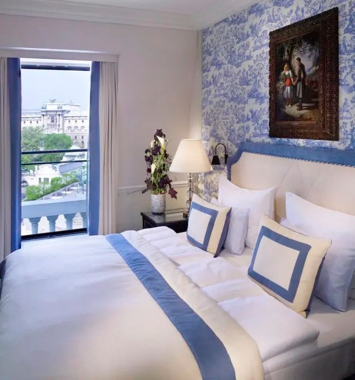 Elegantes Hotelzimmer mit Doppelbett und Ausblick auf Wien.