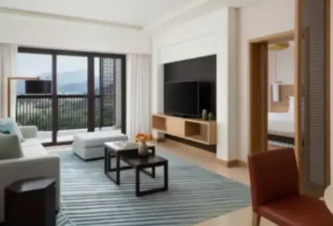 Moderne Suite mit Sitzbereich und Blick auf die umliegenden Berge vom Balkon.