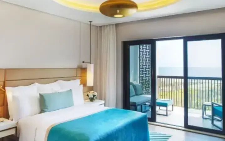 Helles Junior Suite Zimmer mit Balkon und Gartenaussicht im InterContinental Fujairah.