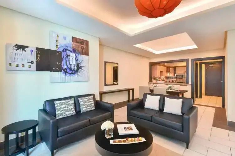 Moderner Wohnbereich der Suite mit stilvollen Sofas und Kunst an den Wänden