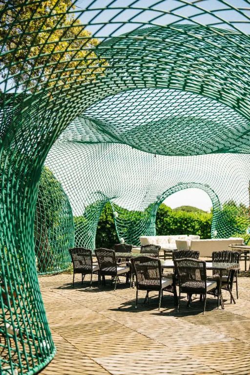 Moderne Sitzgruppe unter einem stilvollen Netz-Pavillon im Garten.