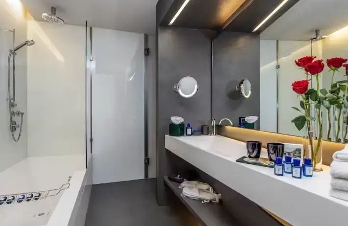 Elegantes Badezimmer mit großem Spiegel und moderner Waschtischgestaltung.
