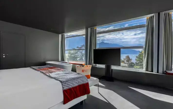 Stylisches Schlafzimmer der Sky Presidential Suite mit großem Fensterblick über die Landschaft