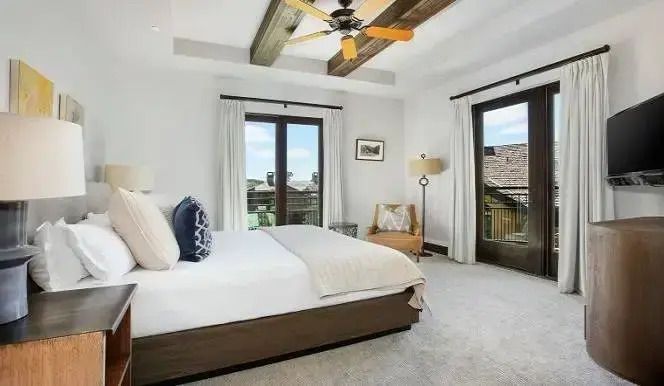 Helles Zimmer mit Balkon und Holzbalken an der Decke
