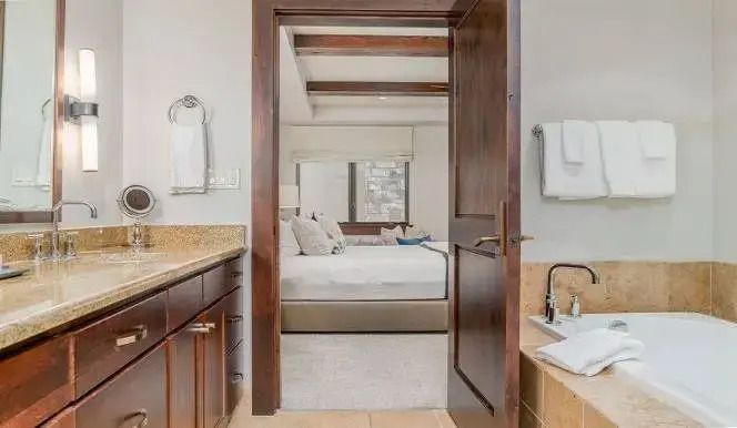 Blick vom Bad ins elegante Schlafzimmer mit Holzdetails