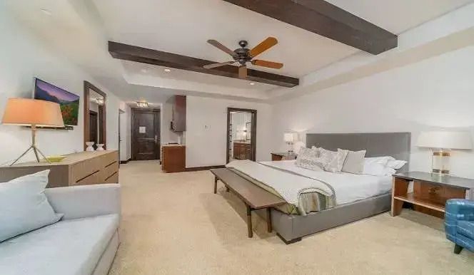 Geräumiges Schlafzimmer mit Holzbalkendecke und modernem Dekor