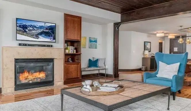 Wohnzimmer mit Kamin und gemütlicher Sitzecke mit Holzelementen