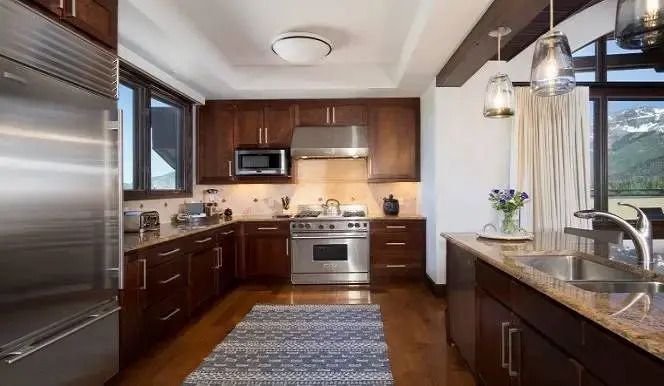 Moderne Küche mit hochwertigen Geräten und Holzelementen im Penthouse.