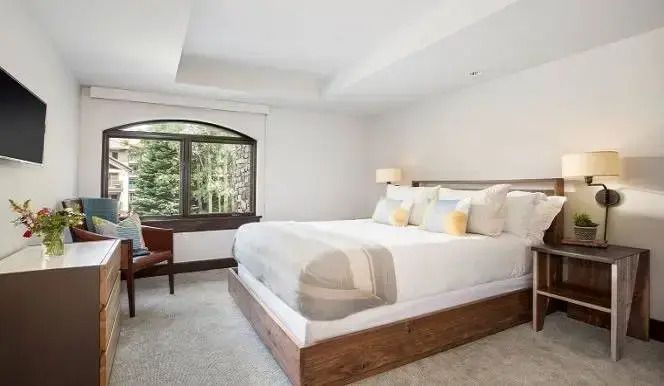 Helles Schlafzimmer mit modernem Dekor und großem Fenster mit Waldsicht