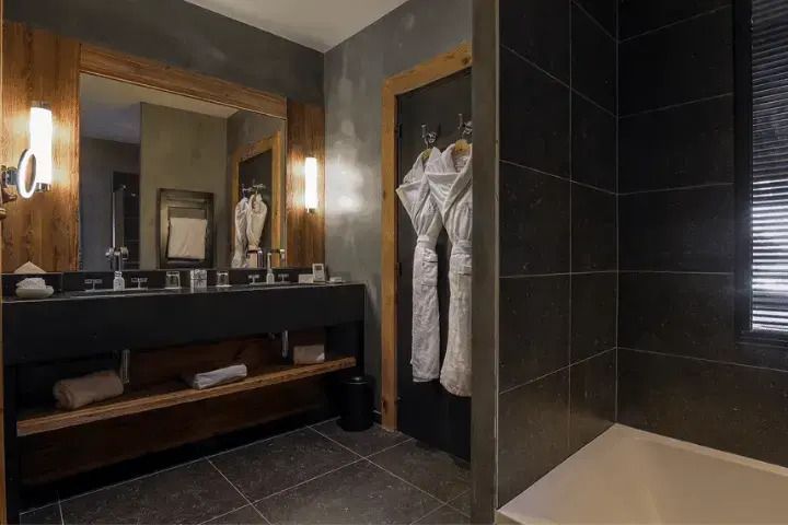 Modernes Badezimmer mit großem Spiegel und zwei Bademänteln.