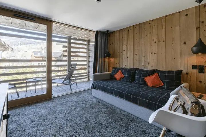 Wohnbereich mit Sofa und Zugang zu einem Balkon mit Aussicht.