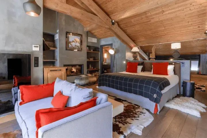 Luxuriöse Suite mit Holzbalkendecke, Kamin, Sofa und Doppelbett