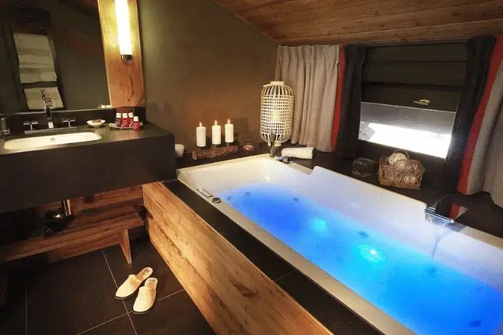 Geräumiges Badezimmer mit Whirlpool, Kerzen und moderner Ausstattung