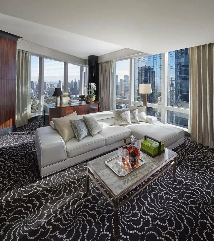 Geräumiges Wohnzimmer der Präsidenten Suite mit Blick auf die Skyline und komfortablem Sofa.