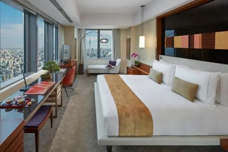 Geräumiges Deluxe Zimmer mit großem Bett und Panoramablick auf die Stadt.