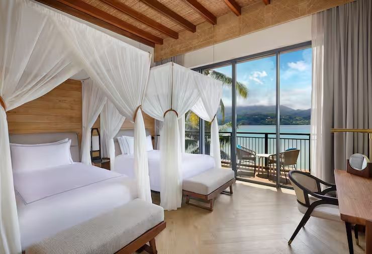 Suite mit zwei Himmelbetten und Balkon mit Meerblick im Mango House Seychelles