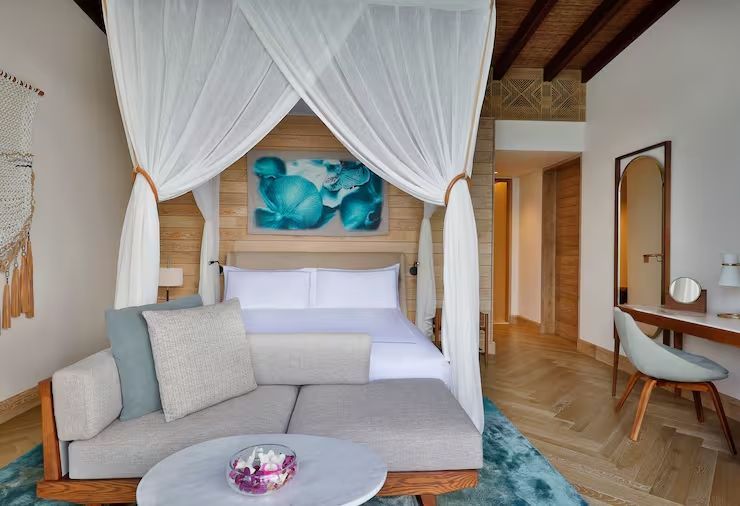 Elegant eingerichtetes Schlafzimmer mit Himmelbett und moderner Kunst an den Wänden