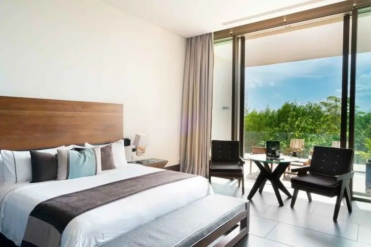 Helle Suite mit modernem Dekor und Blick auf den Garten durch eine große Glasfront