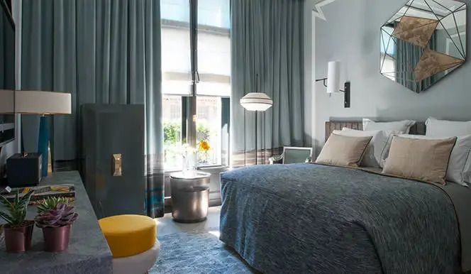 Helles Hotelzimmer mit Doppelbett und modernen Möbeln im Nolinski Paris.