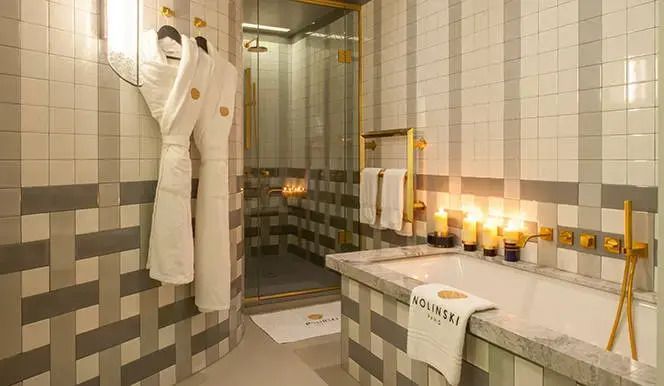 Luxuriöses Badezimmer in der Josephine Doppel Suite mit Marmorakzenten und Kerzenlicht.