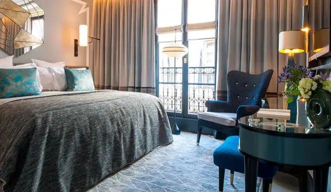 Elegantes Schlafzimmer mit Doppelbett und großen Fenstern in der Superior Suite Nolinski Paris