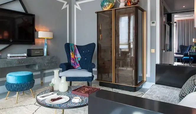 Gemütliche Sitzecke mit Sessel und Schrank in der Superior Suite des Nolinski Paris
