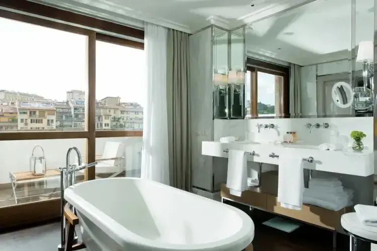Helles Badezimmer mit freistehender Badewanne und großem Fenster