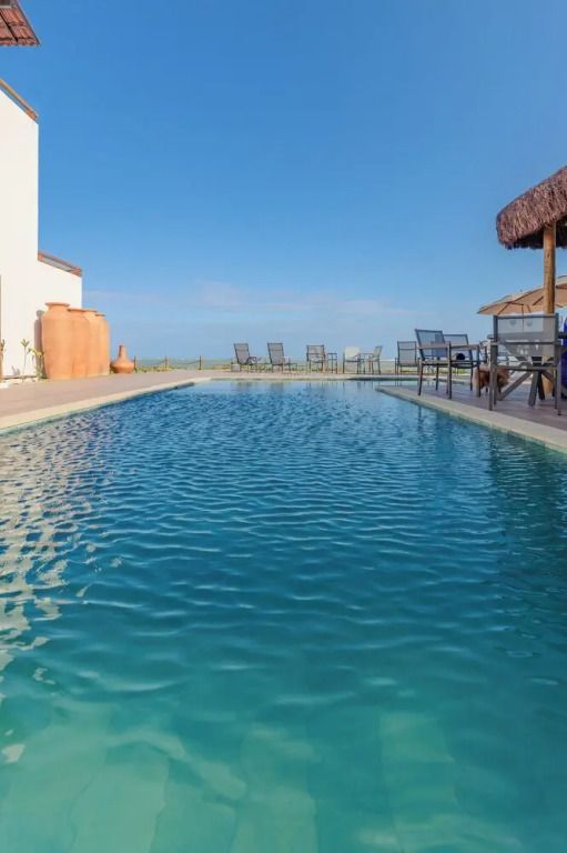 Infinity-Pool mit Liegestühlen und Meerblick bei klarem Himmel