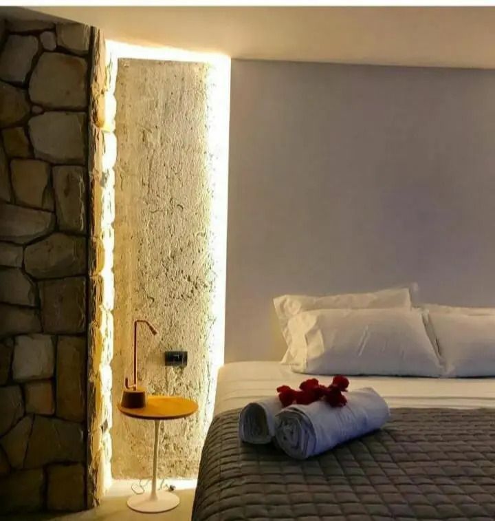Schlafzimmer im Bungalow Penthouse mit beleuchteter Wand und Handtuchdeko