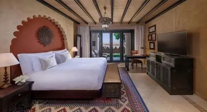 Luxuriöses Schlafzimmer mit Doppelbett und Zugang zur Terrasse im Wüstenresort.