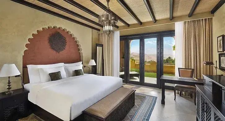Schlafzimmer der Familiensuite mit großem Bett und Aussicht auf die Wüstenlandschaft