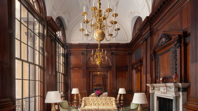 Eleganter Wohnbereich mit hohen Decken und prächtigem Kronleuchter in der Suite