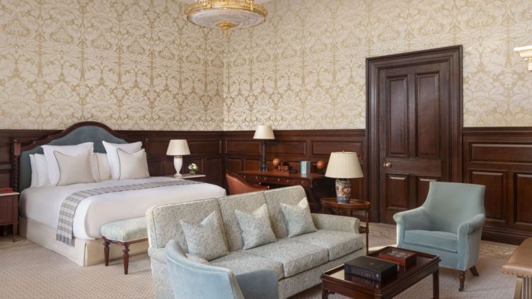 Elegantes Zimmer mit Holzvertäfelung, luxuriösen Möbeln und einem Arbeitsbereich