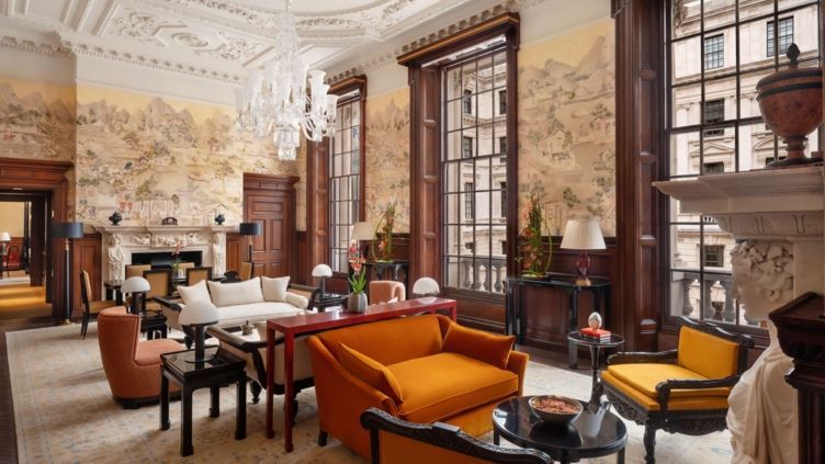 Eleganter Wohnbereich der Suite mit opulenter Decke und maßgefertigten Möbeln.
