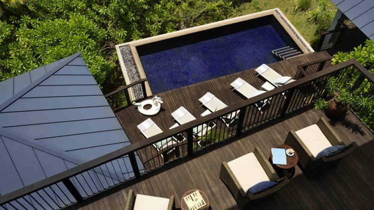 Privater Pool mit Sonnenliegen und üppigem Grün